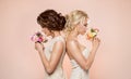 Two Fashion Models with Flowers Bouquet Beauty Portrait, Beautiful Women Studio Shot on beige Royalty Free Stock Photo