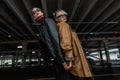 Two fashion models girls in stylish city clothes with a leather jacket with cool sun goggles posing near a parking lot in the city Royalty Free Stock Photo