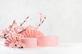 Two fashion spring cylinder podiums mockup, asian fans, branch of gentle pink sakura flowers in sunlight, shadow, white interior.