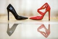 Two fashionable comfortable high heel leather female shoes, red and black, on light copy space background. Style and