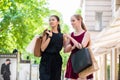 Two fashionable young women walking in the city during shopping Royalty Free Stock Photo