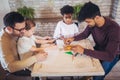 Two fathers play educational games with their children