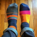 Two feet with colored socks, different trendy colors on the right and left sock. Solidarity to them with Downs syndrome.