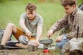 Two fellow campers making tea and preparing food Royalty Free Stock Photo
