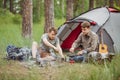 Two fellow campers making tea and preparing food by a tent Royalty Free Stock Photo
