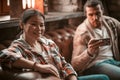 Two Fellow Entrepreneurs Communicate Sitting On The Sofa In Coworking And Looking Mobile Royalty Free Stock Photo