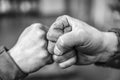 Two fellow workers greeting each other with a handshake using their fists as a symbol of companionship, friendship and solidarity