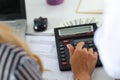 Two female accountants counting on calculator