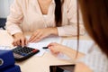 Two female accountants counting on calculator income for tax form completion hands closeup. Internal Revenue Service Royalty Free Stock Photo