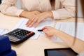 Two female accountants counting on calculator income for tax form completion hands closeup. Internal Revenue Service Royalty Free Stock Photo