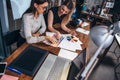 Two female architects working together using color swatches sitting at desk with laptop, graphic tablet in design studio Royalty Free Stock Photo