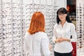 Two female beautiful opticians talking about stylish, trendy glasses Royalty Free Stock Photo