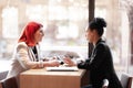 Two female business friends having a meeting at a cafe