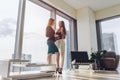 Two female business partners discussing plans standing in modern office at tower block Royalty Free Stock Photo