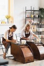 Two female ceramic artists in apron using clay material working in potter studio. Evening freelance distance learning Royalty Free Stock Photo