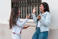 Two female colleagues greet each other high-fiving in the street Royalty Free Stock Photo