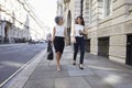 Two female colleagues walking in the street talking