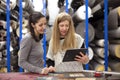 Two female coworkers are looking at something on a digital tablet