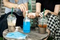 Two female customers cleaning their hand with alcohol gel at coffee shop, new normal concept