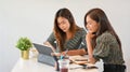 Two female designer working together, sharing idea, using portable tablet