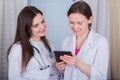 Two female doctors or nurses look at the tablet and discuss therapy Royalty Free Stock Photo