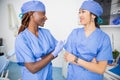 Two female doctors talk in a clinic during work, colleagues of different ethnicities Royalty Free Stock Photo