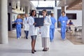 Two Female Doctors In White Coats Discussing Patient Scan In Busy Hospital