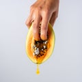 Two female fingers in papaya fruit with a dripping honey. Sex concept Royalty Free Stock Photo