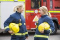 Two female firefighters by a fire engine Royalty Free Stock Photo