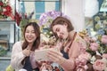 Two female florists demonstrate flower arrangements via online live streaming. Royalty Free Stock Photo