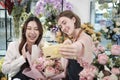 Two female florists demonstrate flower arrangements via online live streaming. Royalty Free Stock Photo