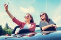 Two female freinds take a selfie photo in cabriolet car during t Royalty Free Stock Photo