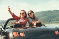 Two female freinds take a selfie photo in cabriolrt car during t Royalty Free Stock Photo