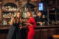 Two female friends are in the bar for a drink and talk. The woman with talks near the ear of the friend Royalty Free Stock Photo