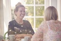 Two Female Friends In Coffee Shop Meeting Up In Socially Distanced Way Viewed Through Window Royalty Free Stock Photo