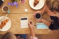 Two Female Friends In Coffee Shop Use Hand Sanitizer And Fill In Test And Trace Form In Pandemic