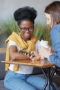 two female friends communicate in coworking or in office. caucasian and African American woman Royalty Free Stock Photo