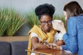 two female friends communicate in coworking or in office. caucasian and African American woman Royalty Free Stock Photo