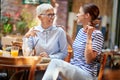 Two female friends of different generations have a friendly talk while they have a drink in the bar. Leisure, bar, friendship,