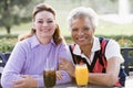 Two Female Friends Enjoying A Beverage By A Golf C