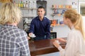 Two female friends flirting with handsome barman Royalty Free Stock Photo