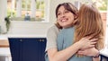 Two Female Friends Greeting And Hugging In Kitchen At Home Royalty Free Stock Photo