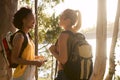 Two Female Friends With Map And Backpacks On Vacation Hiking By Lake At Sunset Together Royalty Free Stock Photo