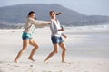 Two female friends playing on the beach Royalty Free Stock Photo