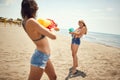 Two female friends playing with water-guns on sandy beach Royalty Free Stock Photo