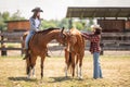 Two female friends on a ranch are getting ready for a horse ride Royalty Free Stock Photo