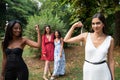 Two female friends show biceps with two female friends behind looking at them, female empowerment concept Royalty Free Stock Photo