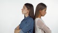Two female friends standing back to back looking angry after having a fight Royalty Free Stock Photo