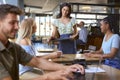 Two Female Friends At Table Meeting In Busy Coffee Shop Talking To Waitress Royalty Free Stock Photo