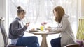 Two female friends talking laughing in a cafe Royalty Free Stock Photo